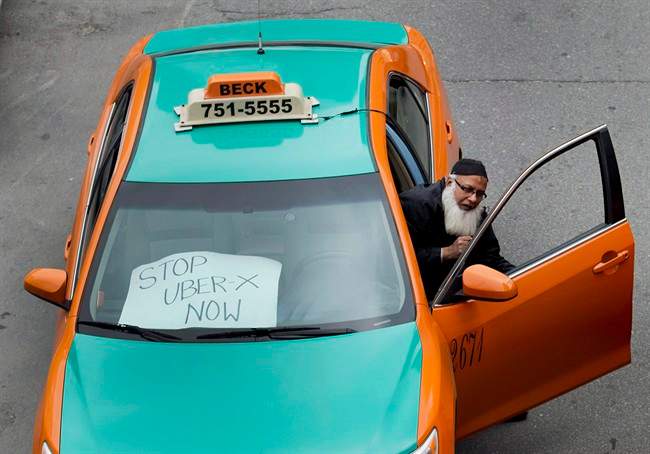 A taxi driver protests Uber in Toronto on June 1, 2015. An Ontario judge has sided with the ride-hailing service Uber in its legal dispute with the City of Toronto.The city sought a permanent injunction on the company's operations, arguing Uber is a taxi company and must abide by the city's regulations. 