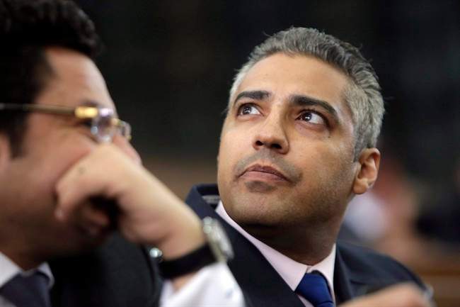 Canadian Al-Jazeera English journalist Mohamed Fahmy, listens to his lawyer, Khaled Abou Bakr during his retrial in a courtroom, of Tora prison, in Cairo, Egypt on June 1, 2015. 
