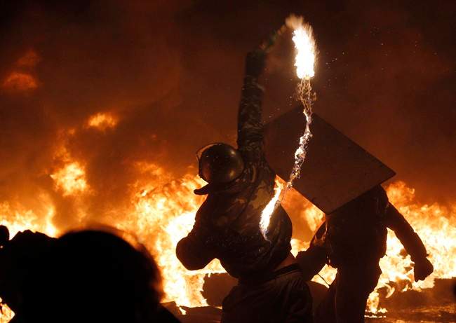 A protester throws a Molotov cocktail during clashes with police in central Kyiv, Ukraine, early Saturday, Jan. 25, 2014.