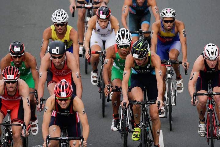 Brazil's Reinaldo Colucci, center, is followed by Mexico's Irving Perez as they ride in the middle of a pack during the Men's Triathlon at the Pan Am Games in Toronto, Ontario, Sunday, July 12, 2015.