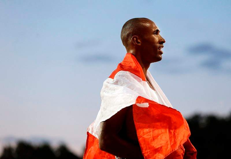Decathlon champion Damian Warner of Canada wears a national flag following his win in the men's decathlon 1500 meter run at the Pan Am Games Thursday, July 23, 2015, in Toronto. 