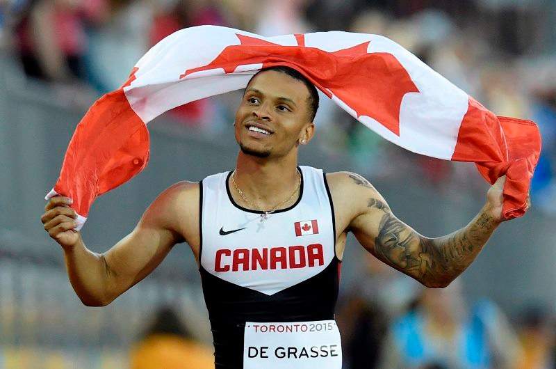 Andre De Grasse, of Canada, hold a flag after he wins the gold medal in the men's 100m final during the athletics competition at the 2015 Pan Am Games in Toronto on Wednesday, July 22, 2015. 