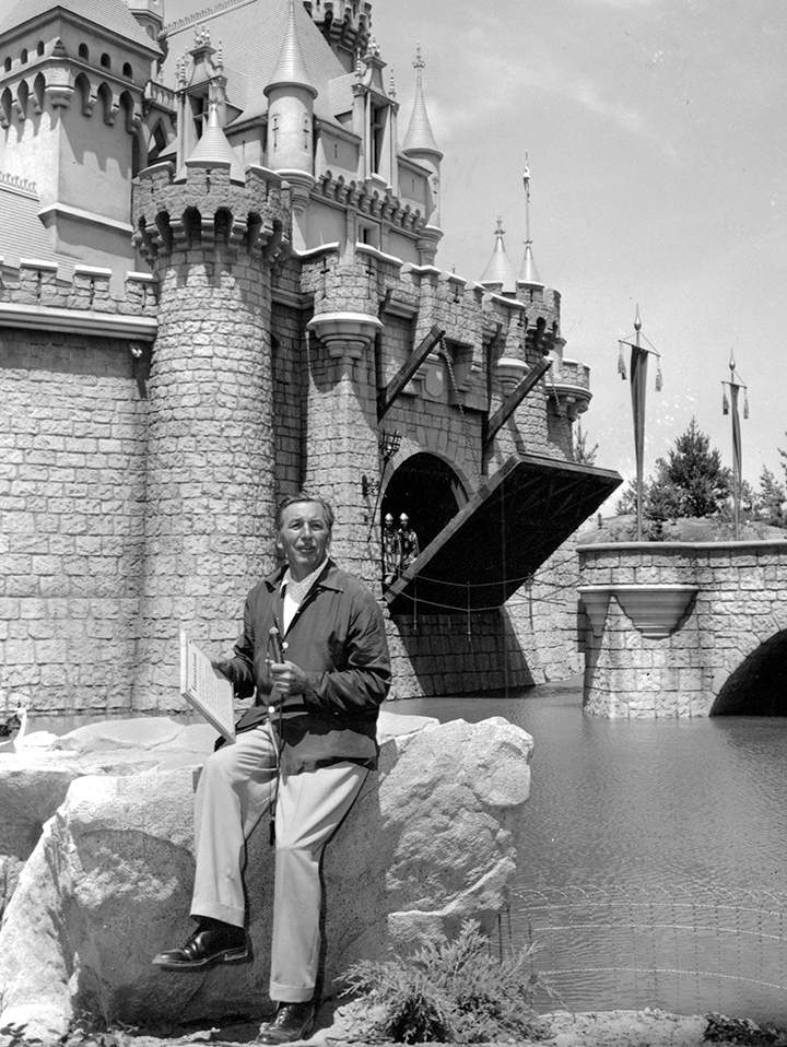 FILE – In this Sunday, July 17, 1955 file photo, Walt Disney sits on a rock in front of the Sleeping Beauty Castle in the Fantasyland section of Disneyland on opening day of the amusement theme park in Anaheim, Calif.