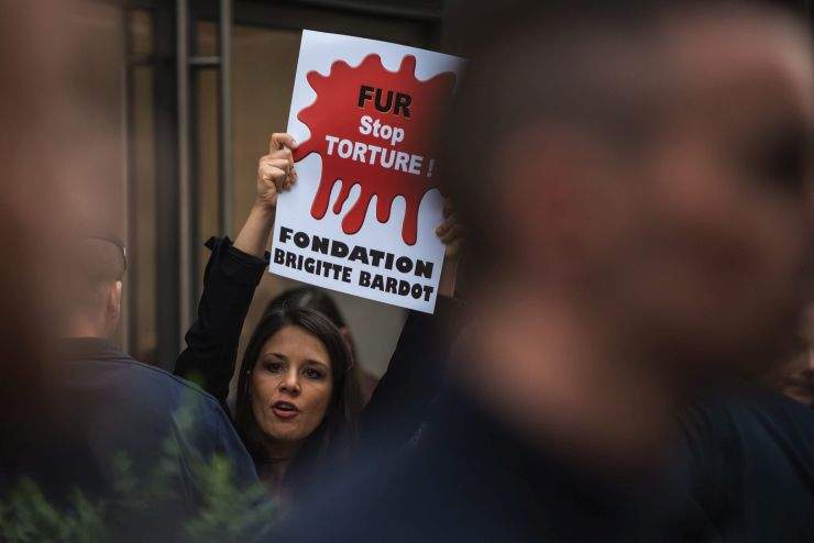 An activist holds a banner reading “FUR: Stop Torture” during a demonstration in Paris, France, Wednesday, July 8, 2015.