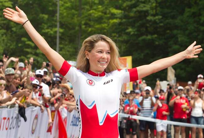 Emily Batty acknowledges the crowd before receiving her gold medal at the Hardwood Mountain Bike Park in Oro-Medonte, Ont., where she finished first in the women\’s mountain bike event at the Toronto 2015 Pan Am Games on Sunday, July 12, 2015.