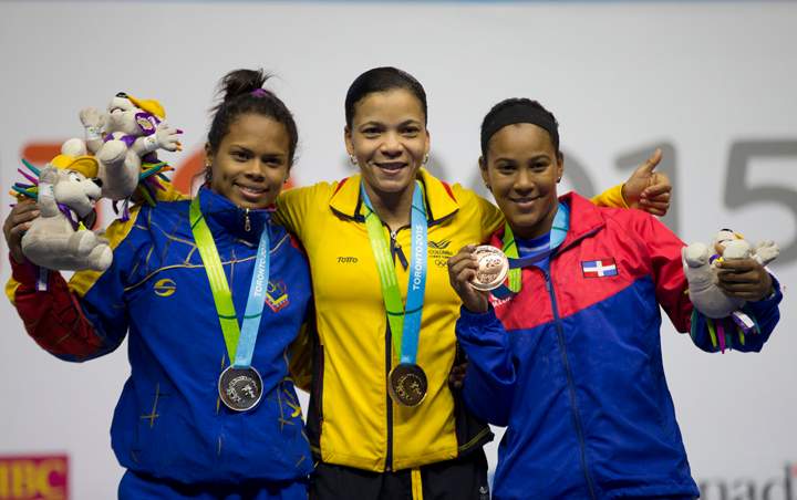 Medal winners in the women's 53kg weightlifting pose together on the podium at the Pan Am Games in Oshawa, Ontario, Sunday, July 12, 2015. From left are silver medal winner Genesis Rodriguez Gomez of Venezuela, gold medal winner Rusmeris Villar Barboza of Colombia, and bronze medal winner Yafreysi Silvestre Velgar of Dominican Republic.