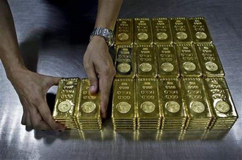 In this Tuesday Oct. 9, 2012 file photo, a technician prepares 1 Kg gold bars of 995.0 purity to pack for delivery at the Emirates Gold company in Dubai, United Arab Emirates. The price of gold, which is often seen as a hedge against inflation and a weak dollar, slumped to its lowest in five years on Monday, July 20, 2015. 