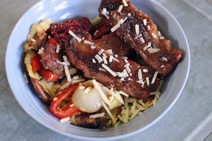 This June 22, 2015 photo shows grilled sausages with potatoes and sun-dried tomatoes in Concord, N.H. This recipe is easily doubled and is a great choice for feeding a crowd.