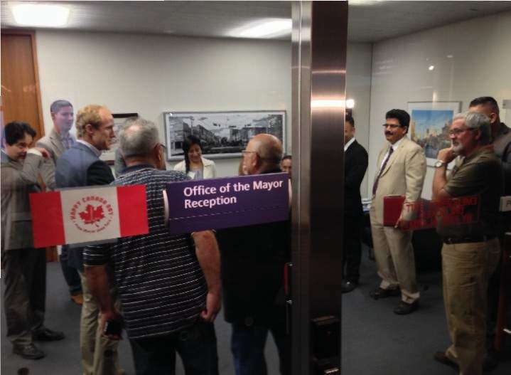 Taxi and Uber reps wait to see Mayor John Tory on July 6, 2015.