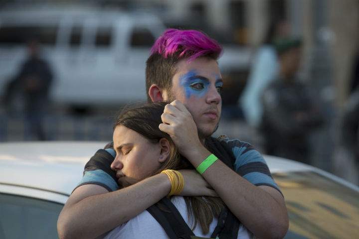 People react after an ultra-Orthodox Jew attacked people with a knife during a Gay Pride parade Thursday, July 30, 2015 in central Jerusalem. Israeli police said several people were stabbed.