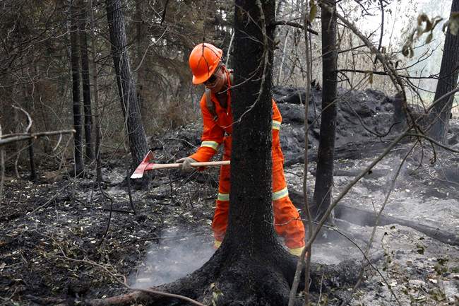 Cpl. Kevin Deng puts out a hot spot at the remote Saskatchewan community of Montreal Lake on Thursday, July 9, 2015. 