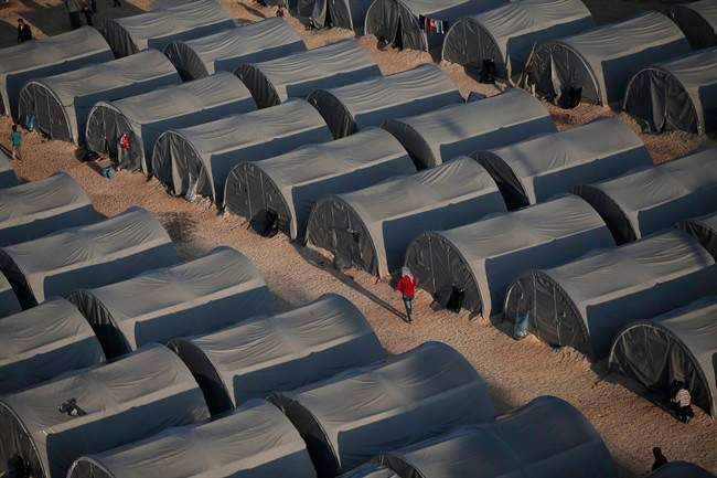 FILE - In this Oct, 17, 2014, file photo, Syrian Kurdish refugees who fled fighting in Kobani, Syria, go about at a refugee camp in Suruc, on the Turkey-Syria border.