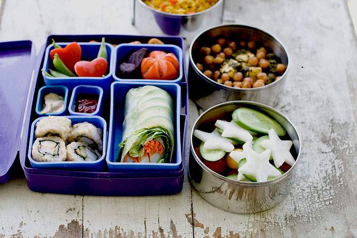 This July 9, 2012 photo shows a Japanese bento box and Indian Tiffin that offer a multinational version of the traditional brown bag lunch in Concord N.H. Today’s lunch “systems” are dominated by bento-style gear, which originated in Japan and involve multiple compartments and containers to hold a variety of foods. And that makes sense for modern kids, who are as likely to be toting sushi and DIY taco kits as they are the classic PB&J.