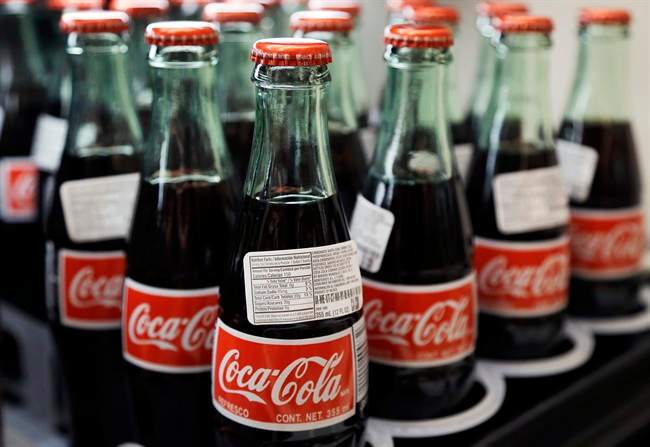 Bottles of Coca-Cola are on display at a supermarket.