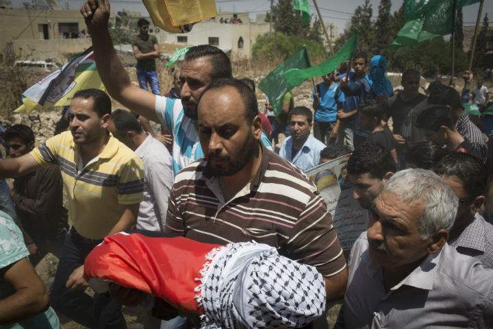 Surrounded by her relatives the body of 18-month-old baby Ali Dawabsha is carried during her funeral on July 31, 2015 in the Palestinian village of Duma, West Bank.