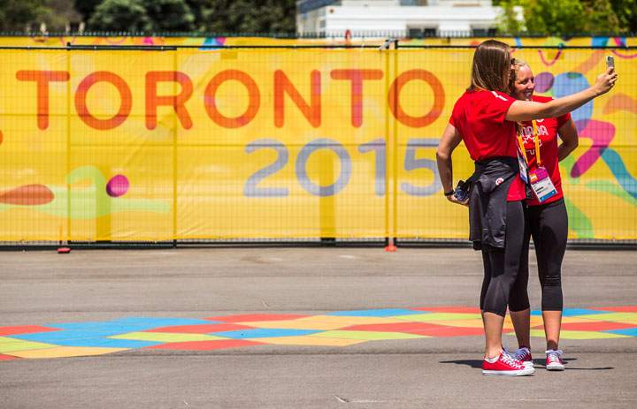 Canadian water polo athletes Monika Eggens, left, and Jacqueline Kohli take a "selfie" in the square inside the Pan American Games athletes village in Toronto, Friday July 3, 2015. 