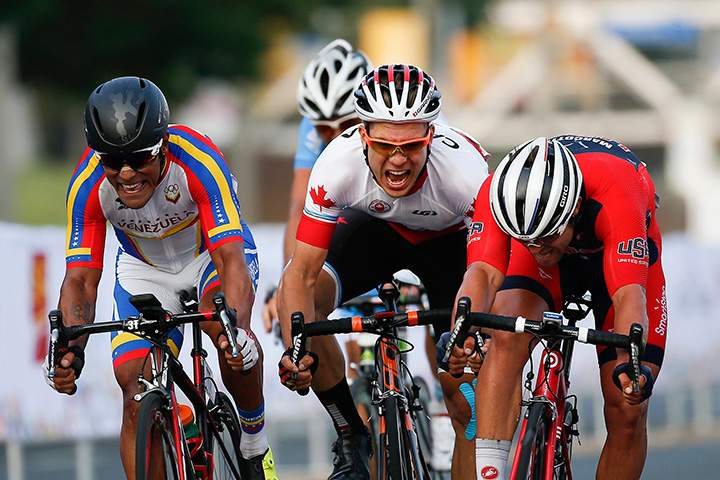 Venezuela’s Miguel Ubeto Aponte, left, Canada’s Guillaume Boivin, center, and USA’s Eric Marcotte, race to the finish line during the men’s road race cycling final at the Pan Am Games in Toronto on Saturday, July 25, 2015.