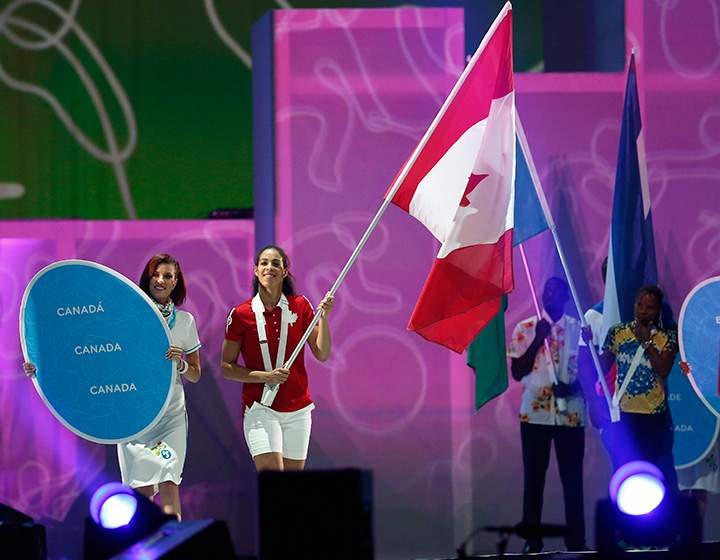 Canada’s Kia Nurse carries the flag during the parade of nations at the closing ceremony of the Pan Am Games on Sunday, July 26, 2015, in Toronto.