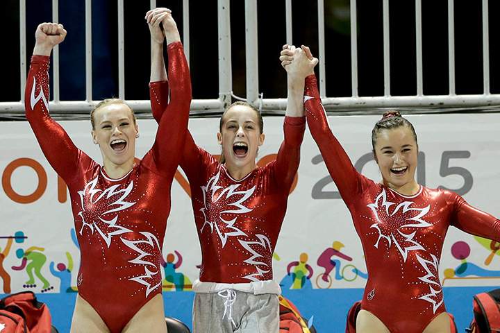 Canada’s Ellie Black, left, Isabela Onyshko, center, and Victoria Woo cheer on teammate Meagan Chant as she wraps up her routine on the floor exercise during women’s artistic gymnastics team competition in the Pan Am Games in Toronto on Sunday, July 12, 2015.