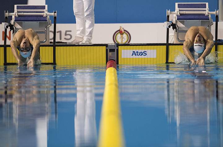 Russell Wood of Canada (L) and Federico Grabich of Argentina (R) compete in the Men’s 100M Backstroke preliminaries at the 2015 Pan American Games in Toronto, on July 17, 2015.