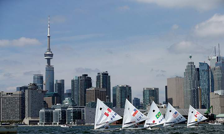 Boats sail off the starting line in the open sunfish medals race during sailing competition in the Pan Am Games in Toronto Sunday, July 19, 2015.