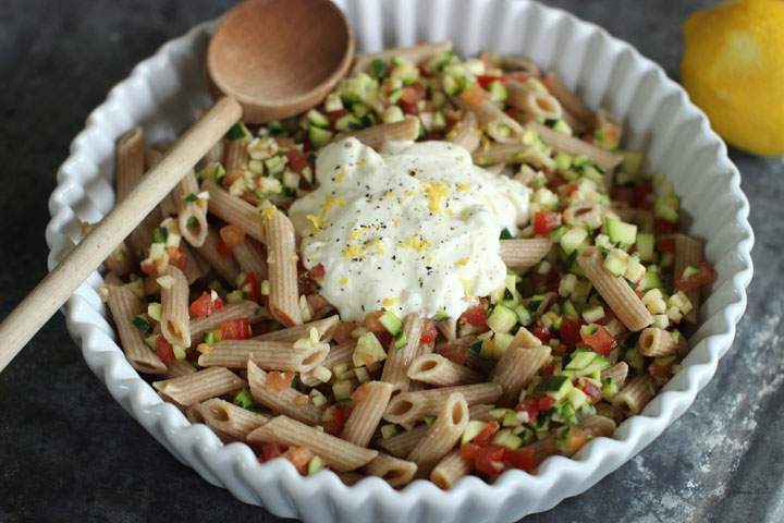 This June 15, 2015 photo shows penne pasta with tomatoes, zucchini and creme fraiche in Concord, N.H., a weeknight-friendly meal that is big on flavor, but not on labor.