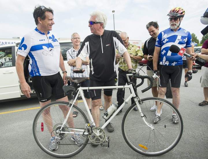 Bloc Québécois leader Gilles Duceppe, right, talks with Parti Québécois leader Pierre Karl Péladeau prior to setting off on their bicycles in Repentigny, Que., Wednesday, July 29, 2015, for a tour of some regions of Quebec.