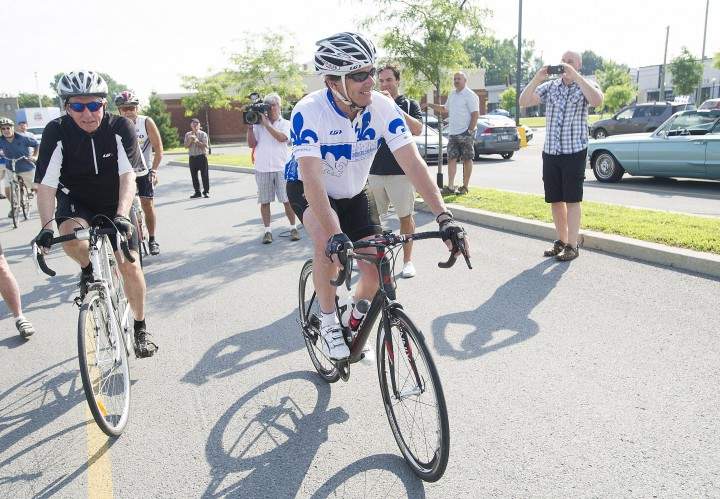 Bloc Québécois leader Gilles Duceppe, right, talks with Parti Québécois leader Pierre Karl Péladeau set off on a tour of Quebec regions on their bicycles in Repentigny, Que., Wednesday, July 29, 2015.