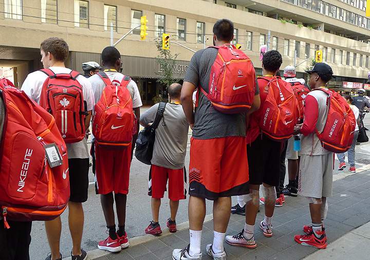 Seven-foot-five Sim Bhullar and other Canadian basketball players wait to cross the street in search of taxis after their bus broke down and failed to meet after practice on Monday, July 20, 2015 at the Mattamy Athletic Centre in Toronto. 