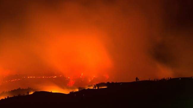 The Blue Creek fire in the Blue Mountains glows in this view south of Walla Walla, Wash., Monday, July 20, 2015. Several wildfires lit up Washington state on Tuesday, closing freeways, including a major east-west artery, destroying at least one home and threatening dozens of others.