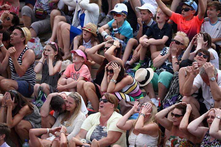 Spectators react as they watch a large screen television showing the Ladies Singles Third Round match between Serena Williams of the United States and Heather Watson of Great Britain on day five of the Wimbledon Lawn Tennis Championships at the All England Lawn Tennis and Croquet Club on July 3, 2015 in London, England.