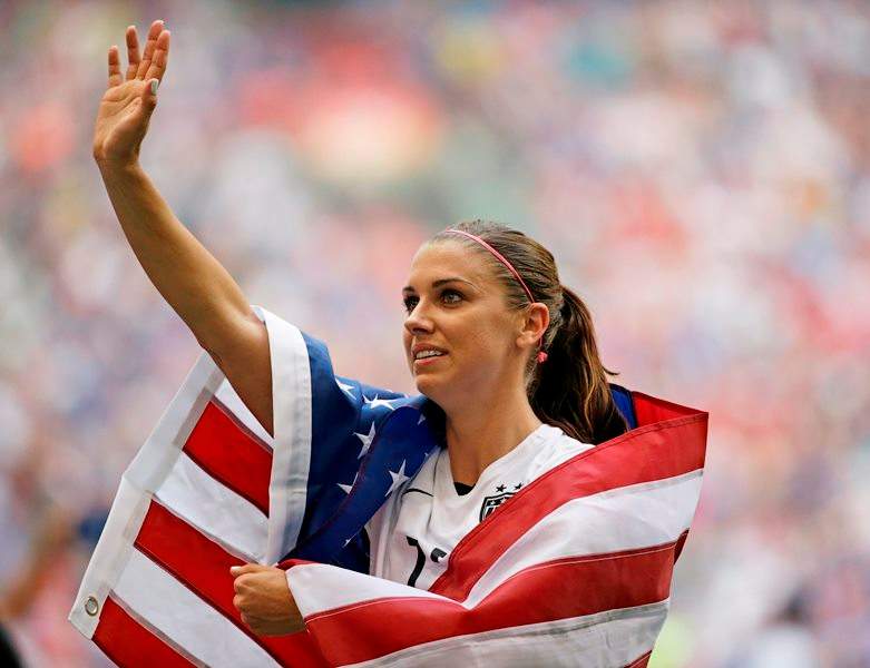 United States’ Alex Morgan is draped in the U.S. flag as she waves to fans after the U.S. beat Japan 5-2 in the FIFA Women’s World Cupsoccer championship in Vancouver, British Columbia, Canada, Sunday, July 5, 2015.