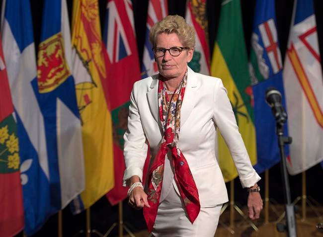 Ontario Premier Kathleen Wynne heads away from the microphone after talking with reporters at the summer meeting of Canada's premiers in St. John's on Thursday, July 16, 2015. 