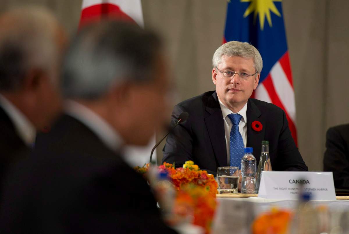 Canadian Prime Minister Stephen Harper listens to United States President Barack Obama deliver opening remarks to members of the Trans Pacific Partnership at the US Embassy in Beijing, China, on Monday, November 10, 2014.