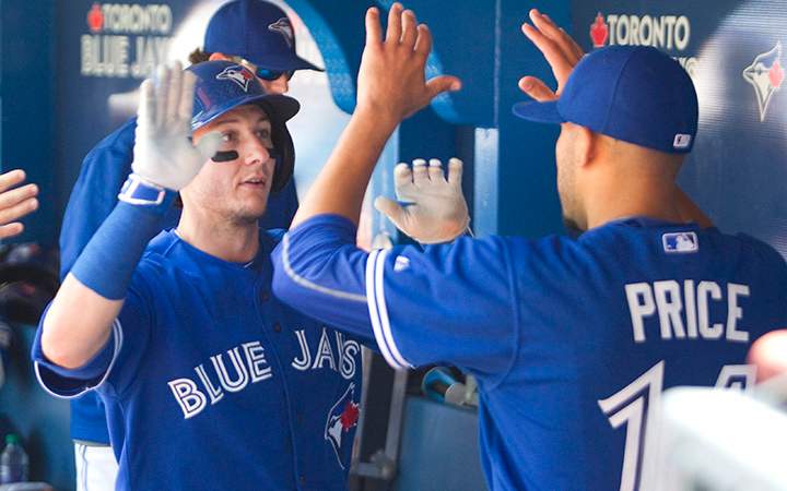 Toronto Blue Jays starting pitcher David Price, right, greets teammate Troy Tulowitzki in the dugout after he scored in the seventh inning of their AL baseball game against the Minnesota Twins, in Toronto on Monday August 3, 2015.