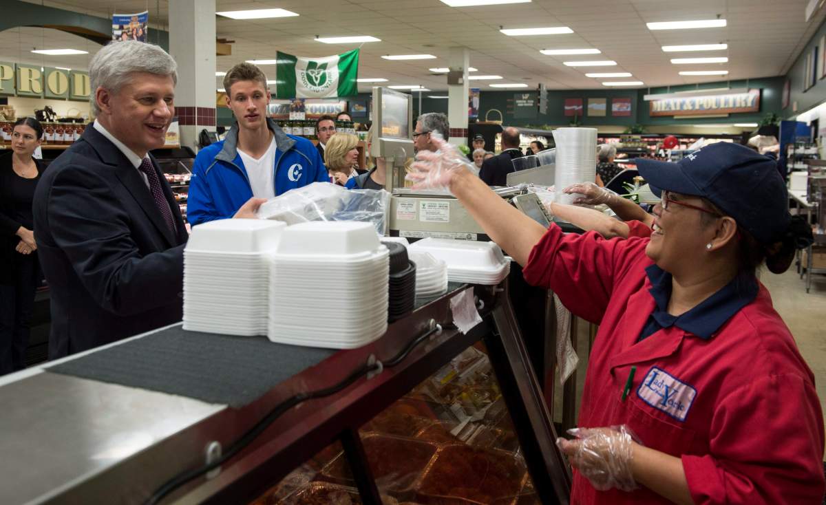 Conservative leader Stephen Harper picks up chicken wings while grocery shopping with his son Ben Tuesday, August 4, 2015 in Toronto. 