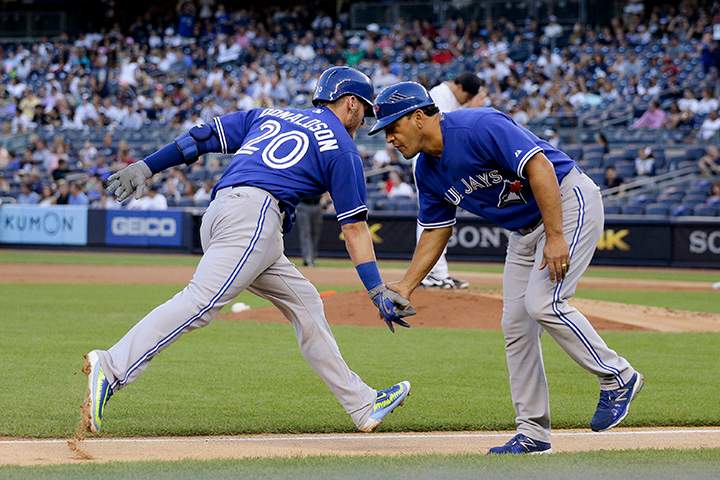 Toronto Blue Jays' Josh Donaldson is greeted by third base coach Luis Rivera after hitting a solo home run against the New York Yankees during the first inning of a baseball game, Friday, Aug. 7, 2015, in New York.
