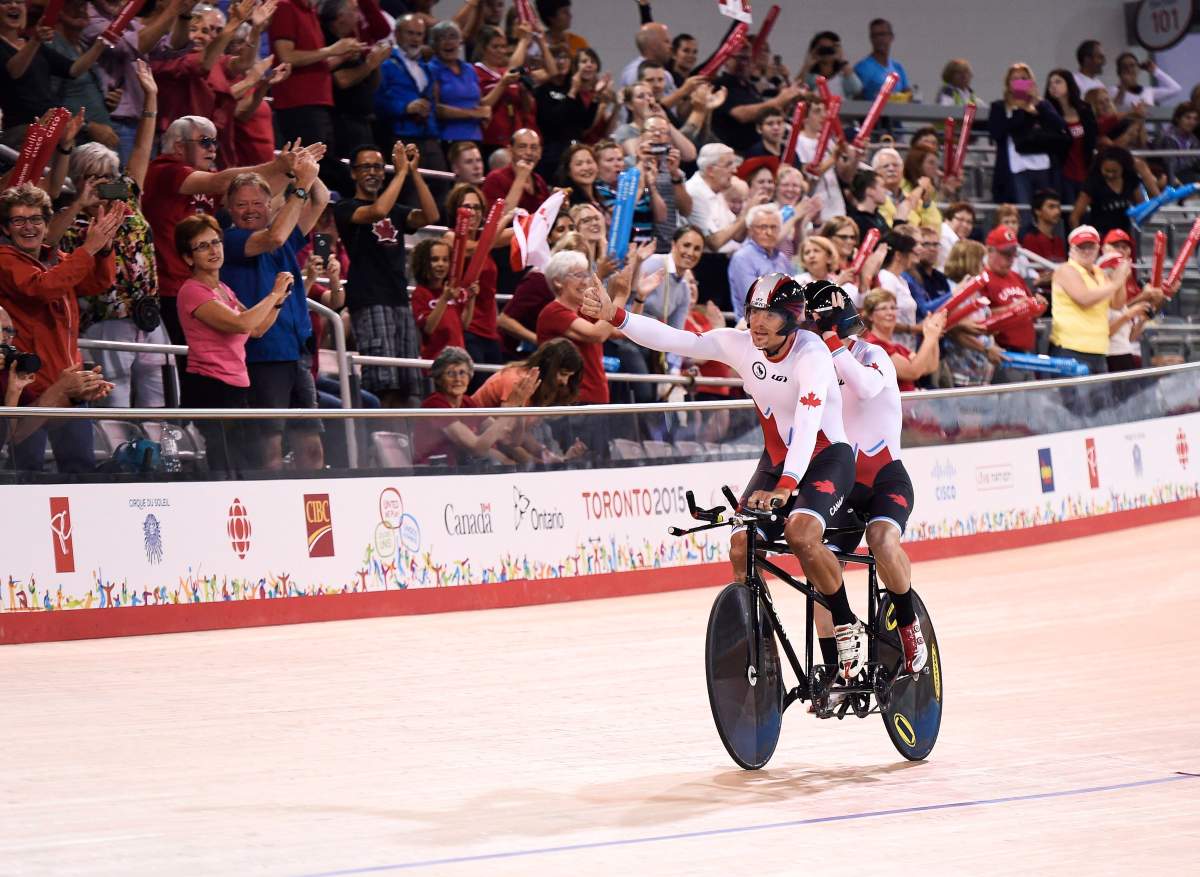 Alexandre Cloutier and Daniel Chalifour of Canada react to the crowed after winning gold in the 4000m tandem pursuit track cycling event during the Parapan Am Games in Milton, Ont., on Monday, August 10, 2015.