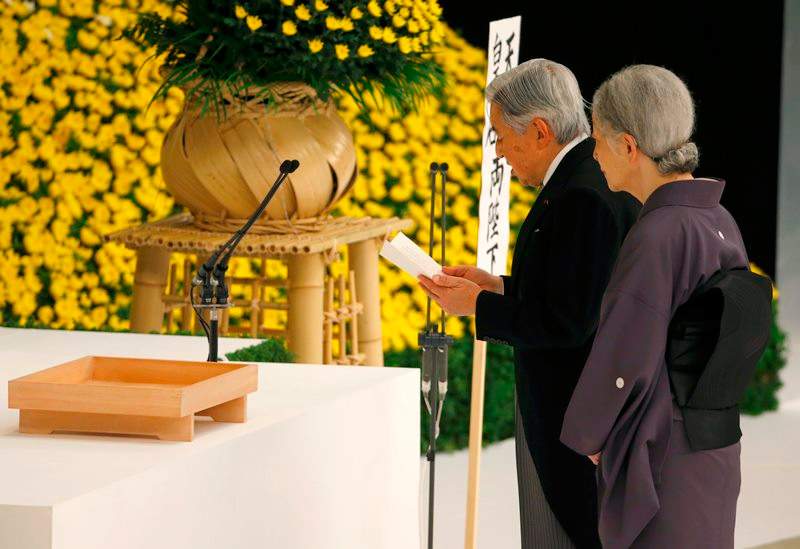 Japan's Emperor Akihito, right, delivers his remarks with Empress Michiko during a memorial service at Nippon Budokan martial arts hall in Tokyo, Saturday, Aug. 15, 2015.