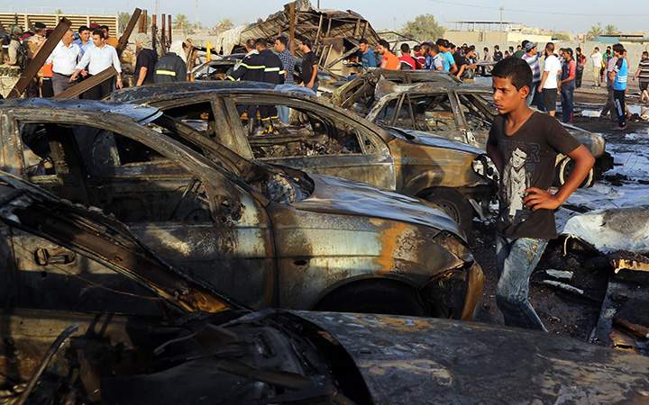 Civilians gather at the scene of a deadly car bomb in the Habibiya neighborhood of Sadr City, Baghdad, Iraq, Saturday, Aug. 15, 2015.