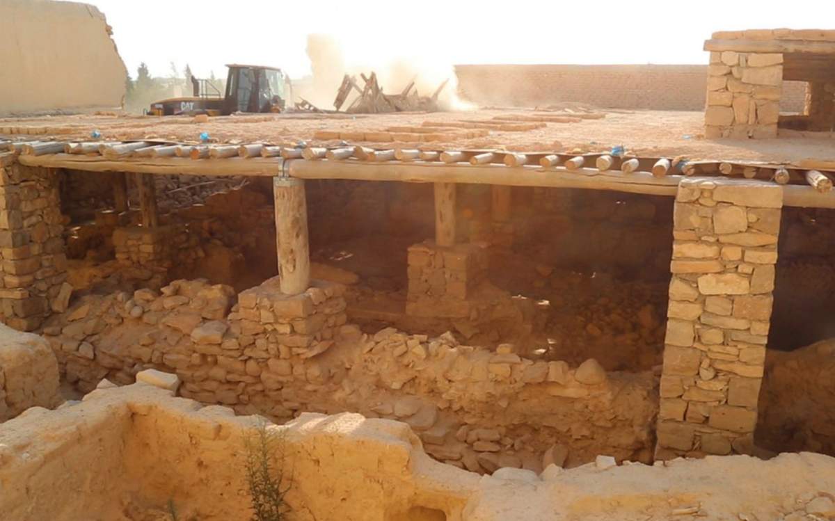 This picture released on late Thursday, Aug. 20, 2015, by an Islamic State militants website, shows a bulldozer, background, of the Islamic State militants destroying the Saint Eliane Monastery near the town of Qaryatain which IS captured in early August, in Homs province, Syria. A Christian clergyman told The Associated Press in Damascus that IS militants also wrecked a church inside the monastery that dates back to the first Christian centuries.
