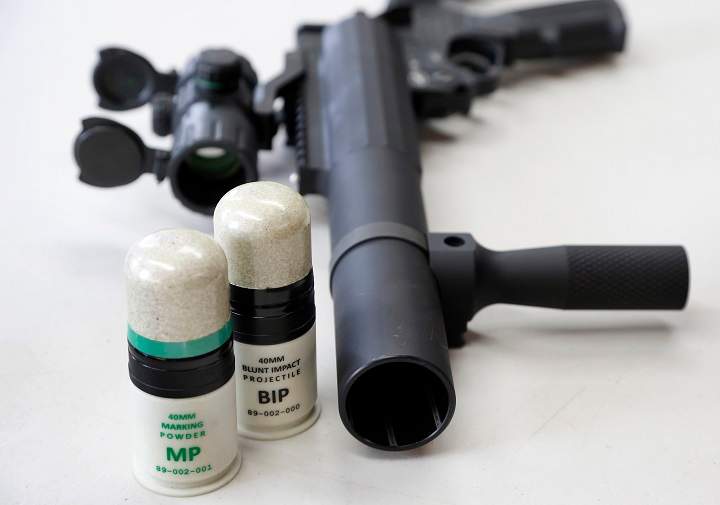 In this Thursday, July 30, 2015 photo, a launcher is displayed on a table next to cartridges that utilize 40mm Blunt Impact Projectiles at Micron Products, Inc., in Fitchburg, Mass. The projectiles utilize new technology developed by the company to provide law enforcement with less-lethal ammunition engineered to cushion and displace the force of impact, designed to cause pain and discomfort but not serious injury. The technology is part of a push to find ways for law enforcement to be able to use force with non-deadly means. (AP Photo/Steven Senne).