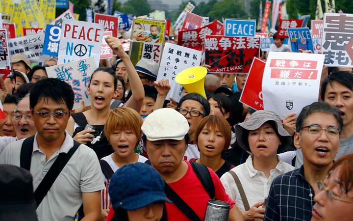 Protesters stage a rally in front of the National Diet building in Tokyo, Sunday, Aug. 30, 2015.  