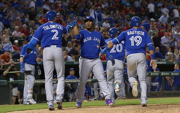 Edwin Encarnacion #10 of the Toronto Blue Jays celebrates with Troy Tulowitzki #2 of the Toronto Blue Jays and Jose Bautista #19 of the Toronto Blue Jays after hitting a grand slam against the Texas Rangers in the top of the sixth inning at Globe Life Park in Arlington on August 26, 2015 in Arlington, Texas. (Photo by Tom Pennington/Getty Images).