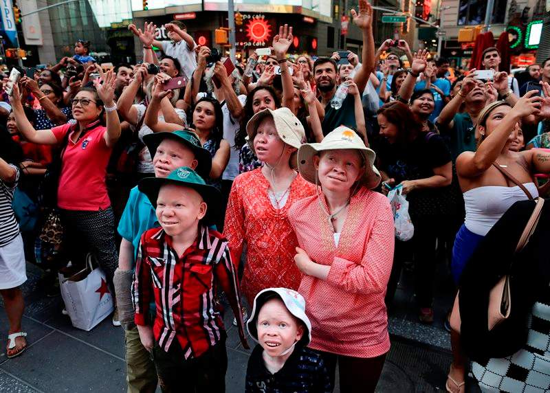 Emmanuel Rutema, Kabula Masanja, Pendo Noni, Mwigulu Magesa and Baraka Lusambo watch the Revlon live camera with a crowd of other tourists during a visit to Times Square in New York on Tuesday, July 28, 2015.