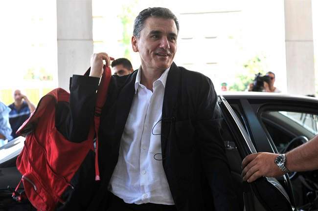 In this Friday, July 31, 2015 file photo, Greek Finance Minister Euclid Tsakalotos arrives for a meeting with senior negotiators at a hotel in Athens. Greece has essentially concluded its bailout talks with its creditors, with just a few details remaining for the deal to be formally clinched, Greek officials said Tuesday, Aug. 11. (Giannis Kotsiaris/InTime News via AP, File).
