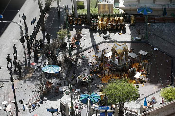 Investigators walk towards the Erawan Shrine at Rajprasong intersection in Bangkok, Thailand, Tuesday, Aug. 18, 2015, the morning after an explosion. 