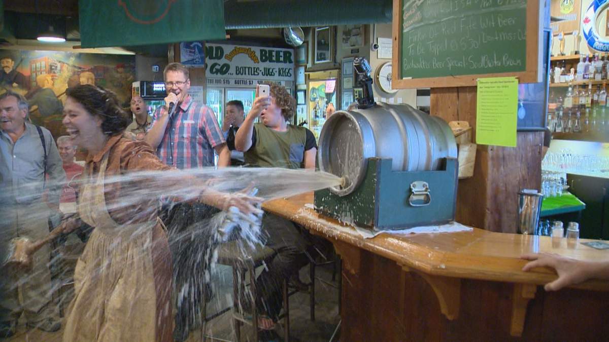 Adrianna Bacheschi from Motherwell Homestead taps the first keg of Motherwell Wheat Beer.