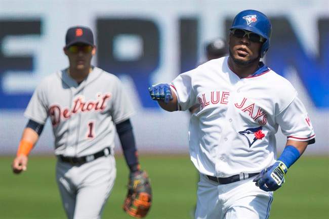 Toronto Blue Jays Edwin Encarnacion (right) rounds the bases after hitting a solo home run off Detroit Tigers starting pitcher Alfredo Simon as Tigers' shortstop Jose Iglesias (left) looks on during first inning Major League baseball action in Toronto on Sunday, August 30 , 2015.