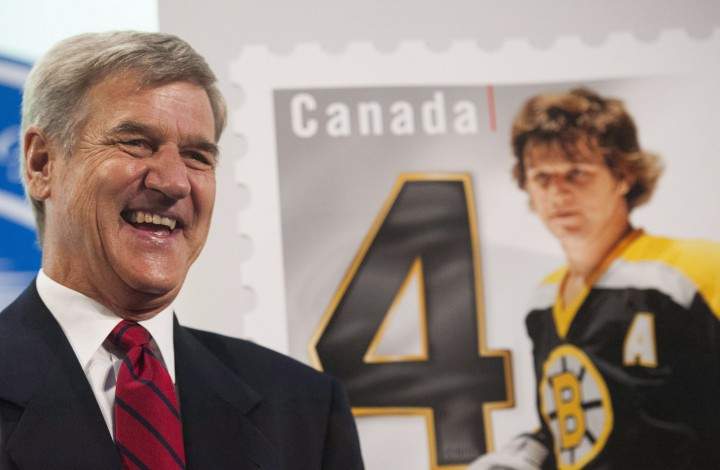 Canadian hockey player Bobby Orr signs autographs with his left hand.
